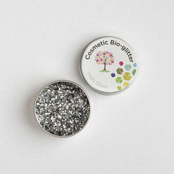 Open pot of The Glitter Tree Holo Silver biodegradable cosmetic glitter showing the sparkle texture, next to a closed pot