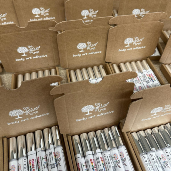 a series of body art adhesive applicators in a custom packaging pizza style box