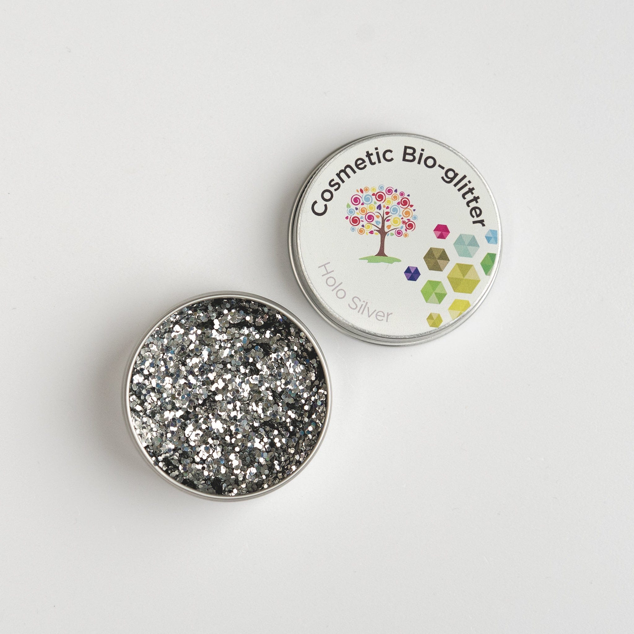 Open pot of The Glitter Tree Holo Silver biodegradable cosmetic glitter showing the sparkle texture, next to a closed pot