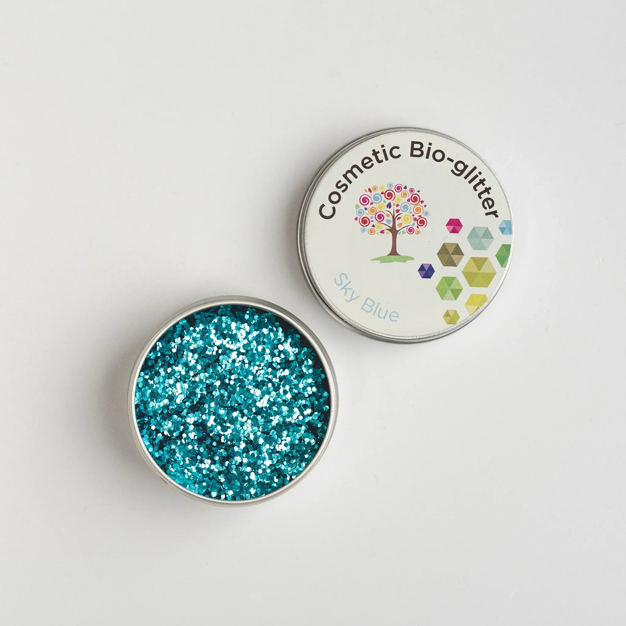 Open pot of The Glitter Tree Sky Blue biodegradable cosmetic glitter showing the sparkle texture, next to a closed pot